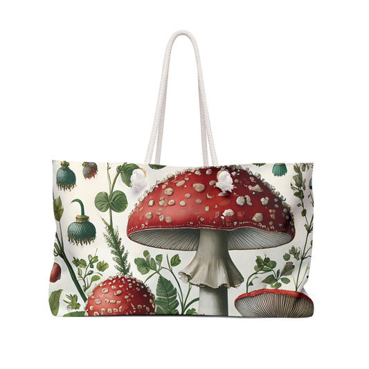 Weekender bag featuring illustrated red mushrooms and greenery in a whimsical cottagecore botanical design with rope handles.