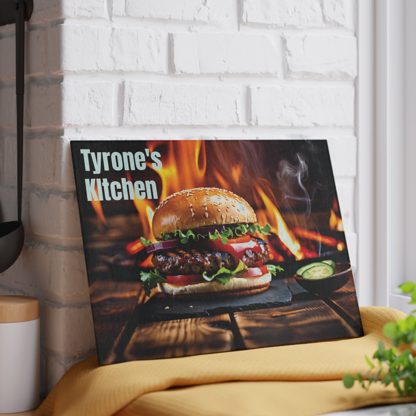 Personalized glass cutting board featuring a flame-grilled burger design on a rustic wood background with a custom name displayed on a kitchen counter.
